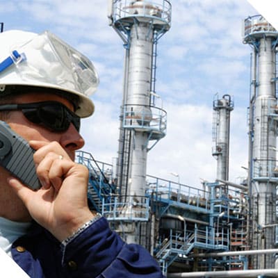 A man on a phone in front of a facility representing career opportunities at machinery control system provider Petrotech in New Orleans, LA