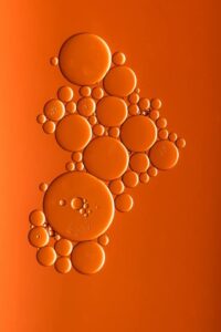 Oil bubbles on an orange background representing the guide to operating efficiently with steam turbine oil that was written by Petrotech, which is based in New Orleans, LA