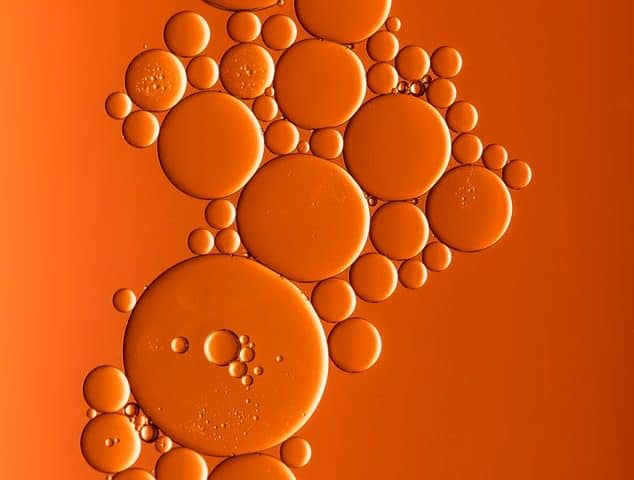 Oil bubbles on an orange background representing the guide to operating efficiently with steam turbine oil that was written by Petrotech, which is based in New Orleans, LA