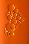 Oil bubbles on an orange background representing the guide to operating efficiently with steam turbine oil that was written by Petrotech, which is based in New Orleans, LA