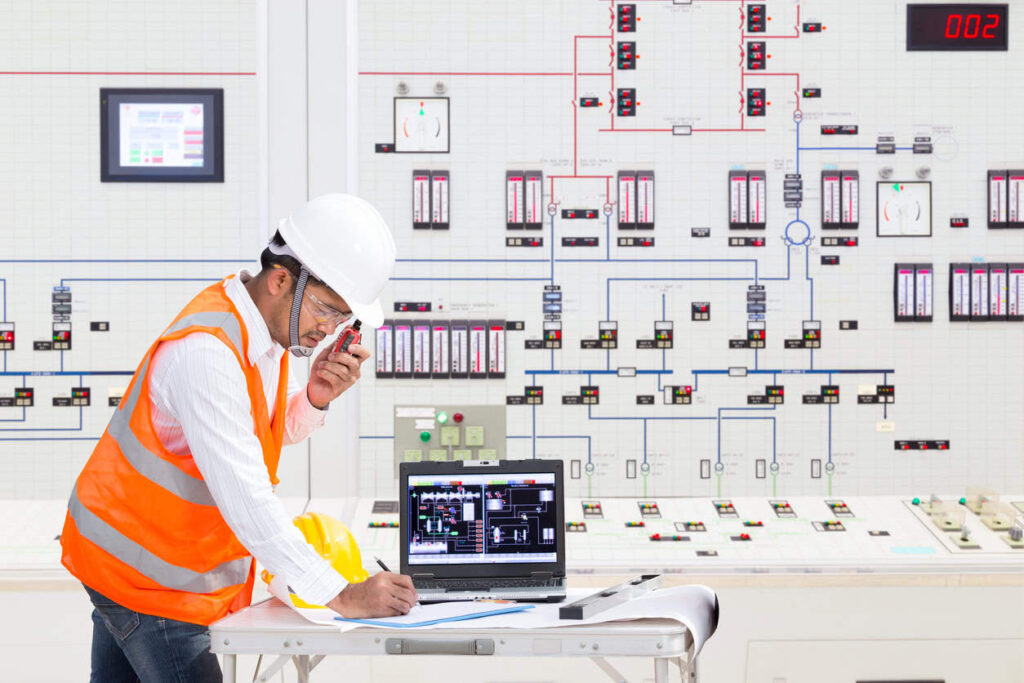 Electrical engineer working at control room of a modern thermal power plant.