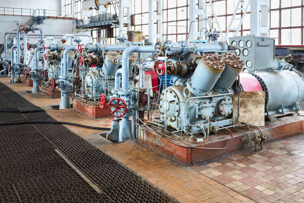 Interior element of chemical enterprise ammonia reciprocating compressors with cylinders and electric motor with control panel, with control devices and alarm systems.